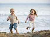 哥哥和妹妹在海滩上跑步图片素材