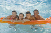 一家人在游泳池的木筏上休息图片素材