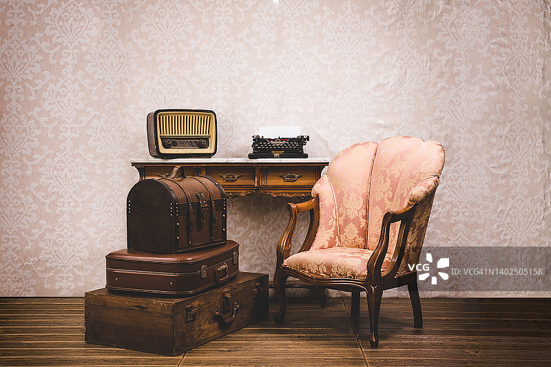 一套舊的古董手提箱，打字機，扶手椅和收音機。圖片素材