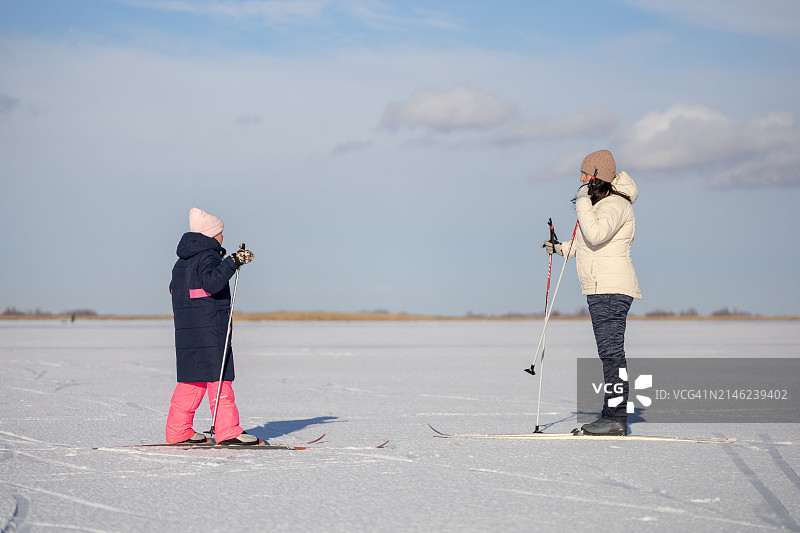 滑雪时母亲和女儿说话相对。图片素材