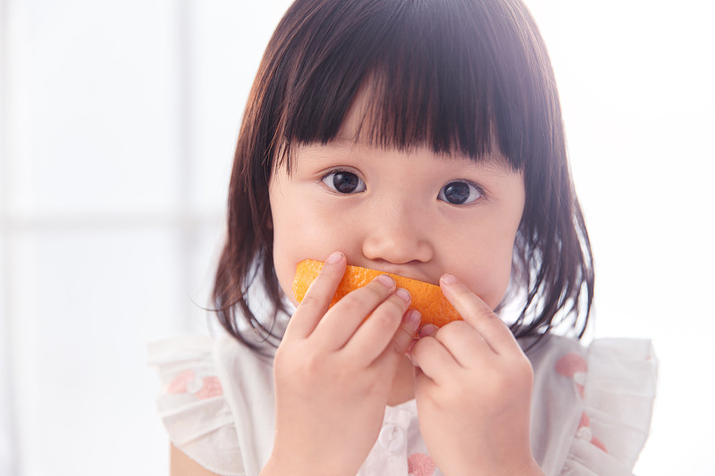 可愛的小女孩在吃橙子圖片下載