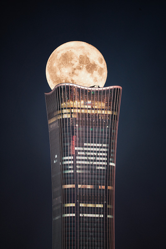中秋节北京中国尊建筑穿过月亮图片下载