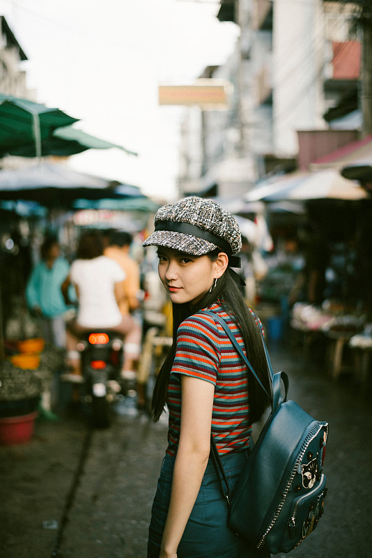 年輕女子戴著帽子站在市場的肖像圖片素材