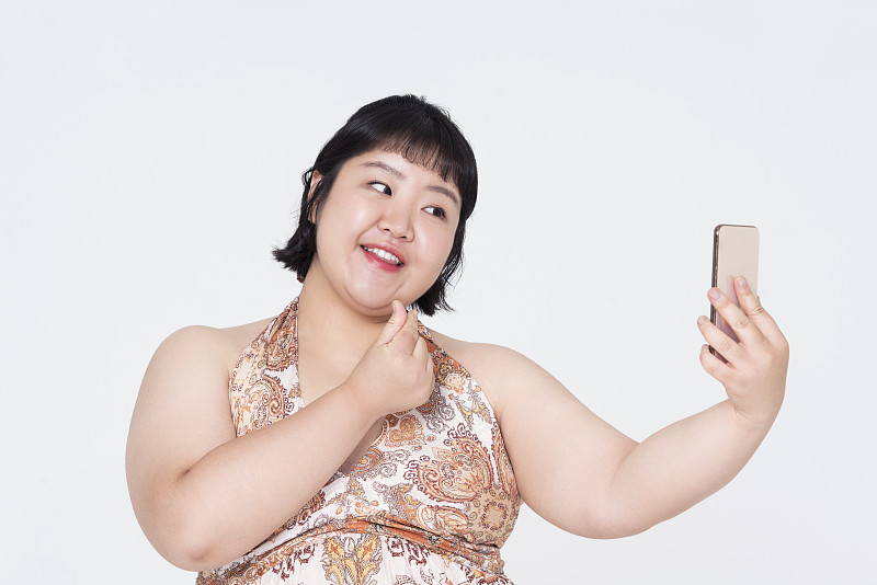 肥胖女子用智能手机自拍图片