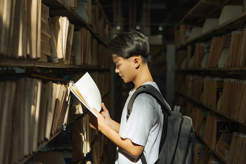 亞洲青年男性在圖書館檔案室里的閱讀圖片下載