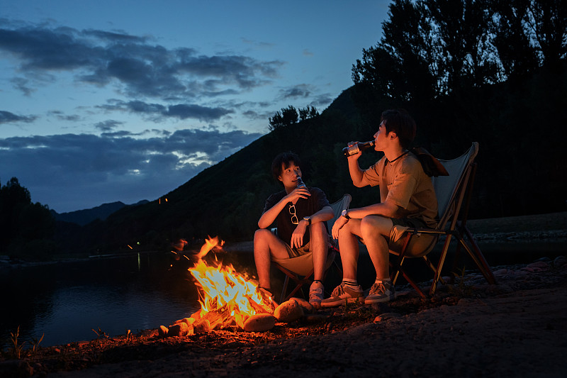 年輕人夜晚在野外篝火露營圖片素材