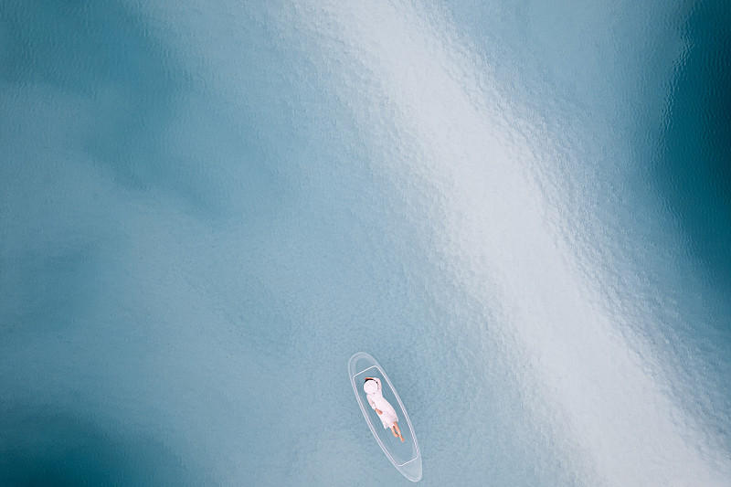 在中国青海大柴旦翡翠湖,在透明“玻璃船”上的的女性游客 航拍视角图片下载