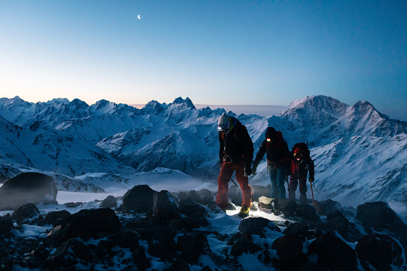 登山隊員在暮色中向山頂進發圖片素材