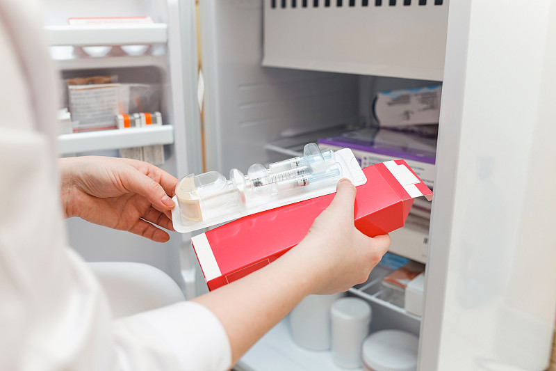 醫生用一次性注射器從冰箱里拿出藥圖片素材