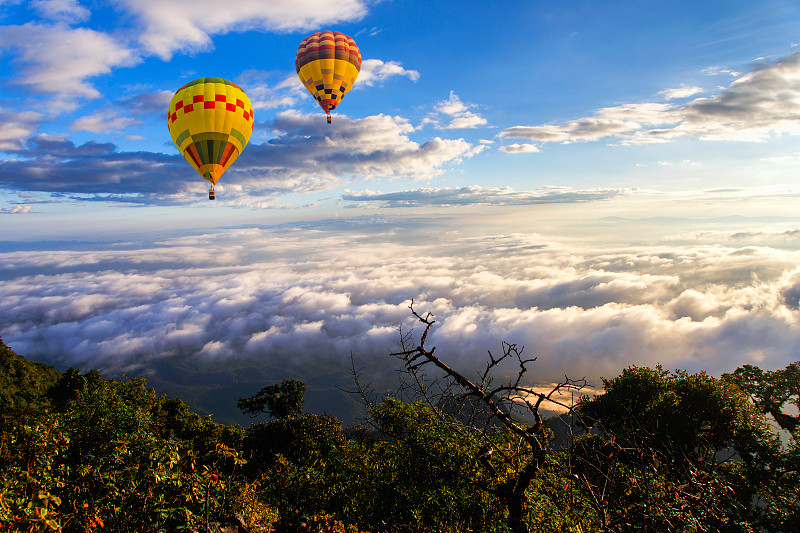 彩色的熱氣球在日出和晨霧中飛過Doi Luang Chiang島。圖片素材