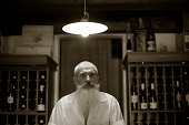 长胡子老人站在一家葡萄酒商店图片素材