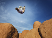 在沙漠的岩石上进行跑酷运动的人图片素材