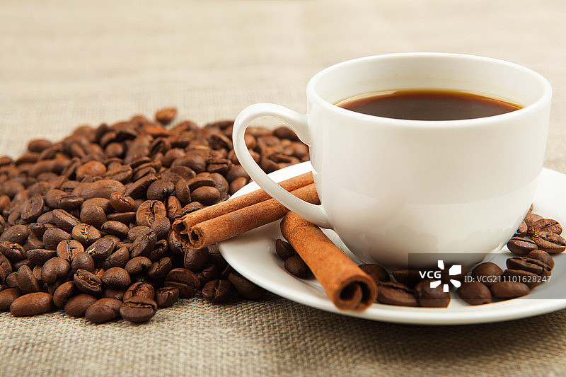 一杯咖啡与肉桂管和咖啡颗粒图片素材