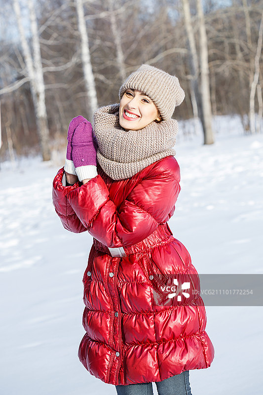 冬天的乐趣。快乐的年轻女子在冬天的森林里玩图片素材
