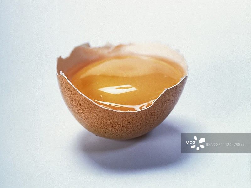 破碎的棕色蛋壳，蛋黄和蛋白在白色背景上图片素材