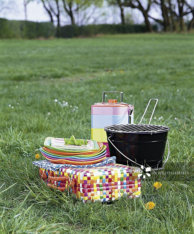 烧烤，午餐盒，盘子和手提箱在草地野餐图片素材