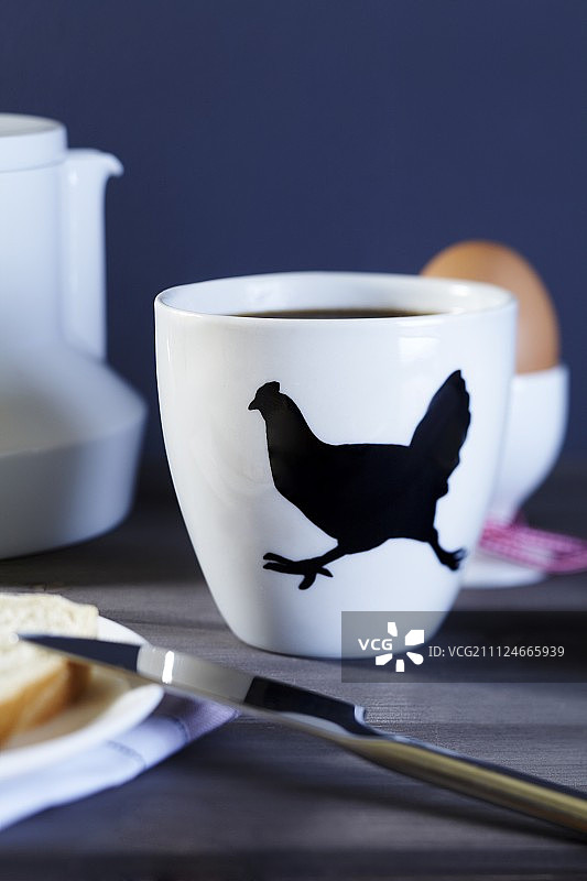 特写咖啡杯与鸡肉图案在早餐桌上图片素材