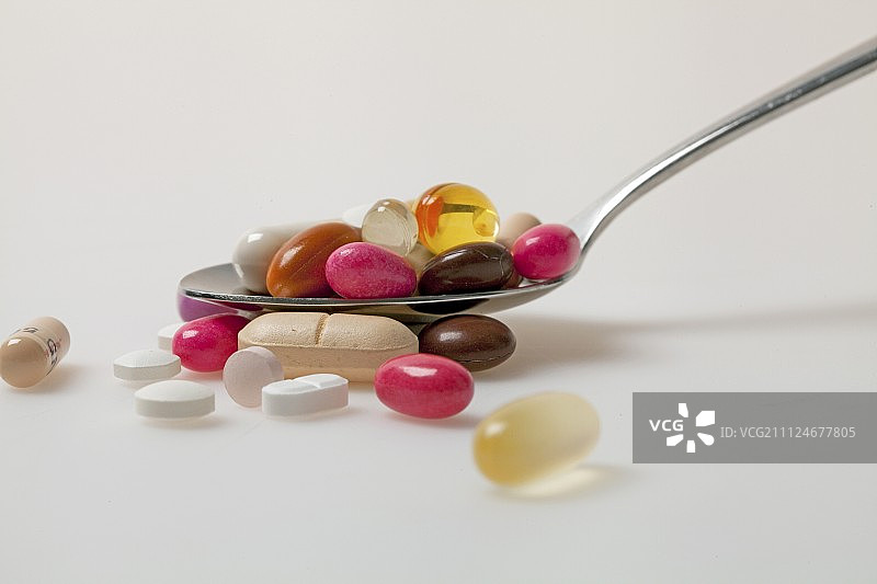 药丸，药片，糖衣和胶囊的特写勺子在白色的背景图片素材