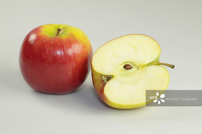 白色背景上的整个和减半的苹果的特写图片素材