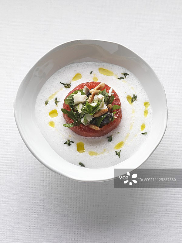 冷的，白色的西红柿汤和一个填充的西红柿图片素材