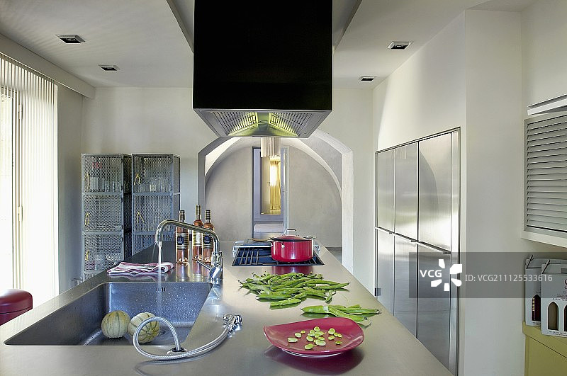 设计师岛状柜台与不锈钢台面和配备橱柜与不锈钢面在厨房图片素材