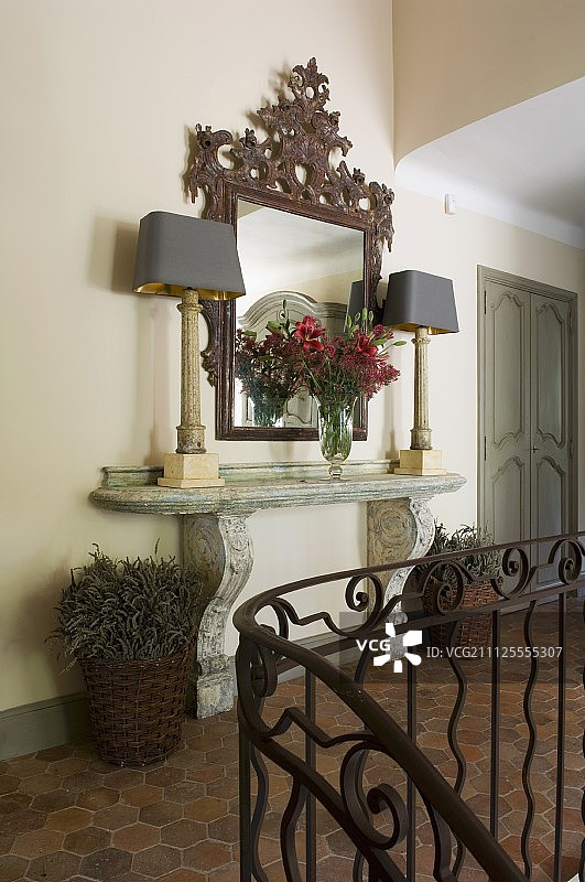 典雅，石头控制台桌子，华丽的镜子和台灯在陶瓦走廊在历史上，法国乡村房子图片素材