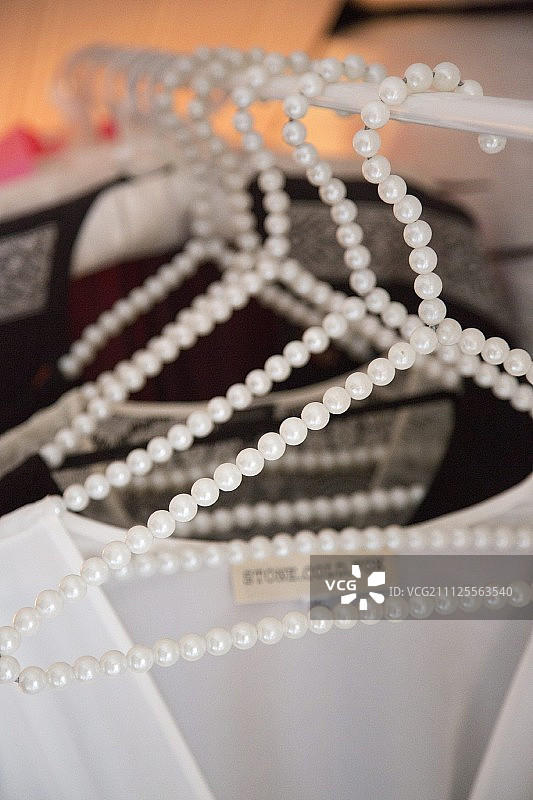 在女士衣柜的衣架上挂着饰有珠子的衣架图片素材