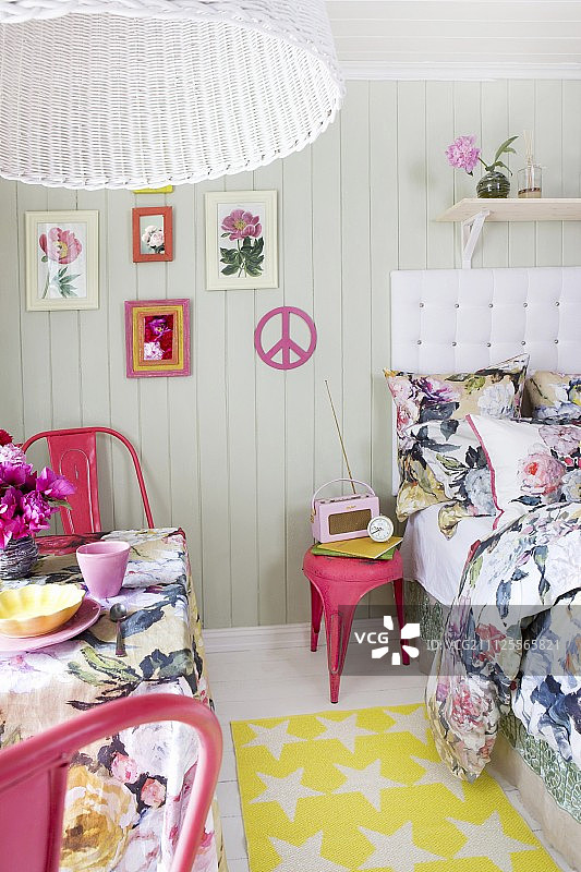 小房间的床和桌子上有花织物，热粉色复古椅子和配件图片素材