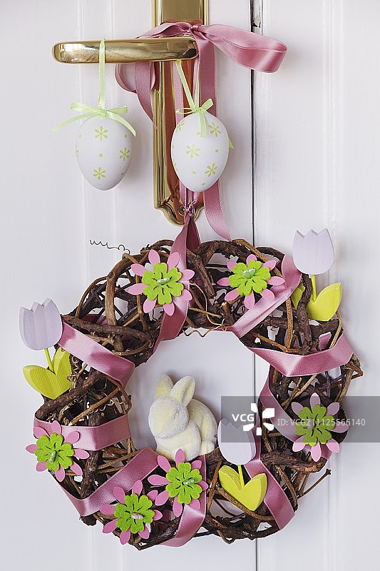 复活节门花环由柳条制成，上面装饰有缎带、毛毡花和木花图片素材