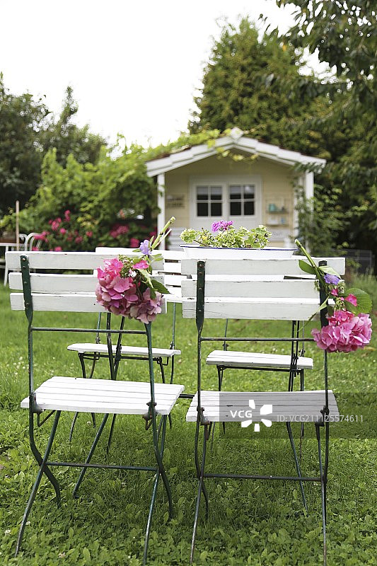 阳台上的草坪上摆放着装饰着绣球花的折叠椅图片素材