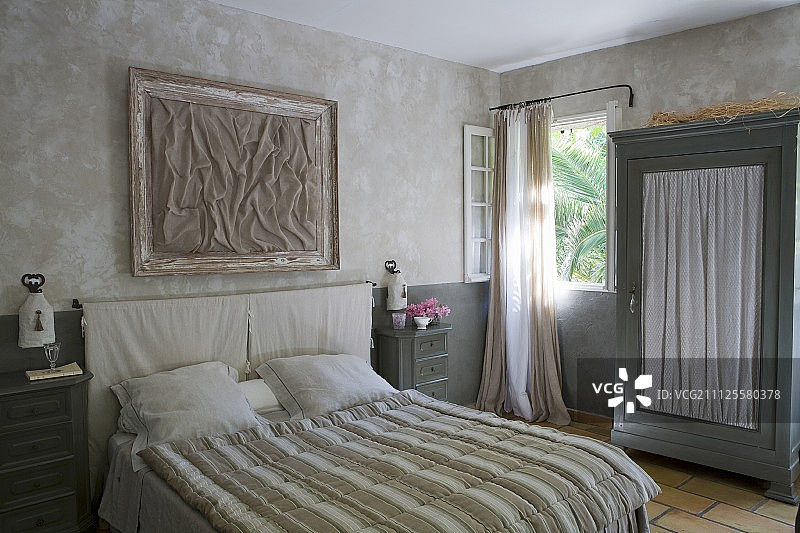 双人床条纹床罩和衣柜收集织物门板在卧室在自然阴影图片素材