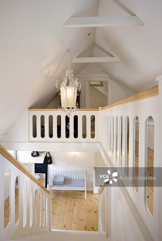 翻修过的阁楼上的楼梯和平台;粉刷成白色的木楼梯和木扶手图片素材