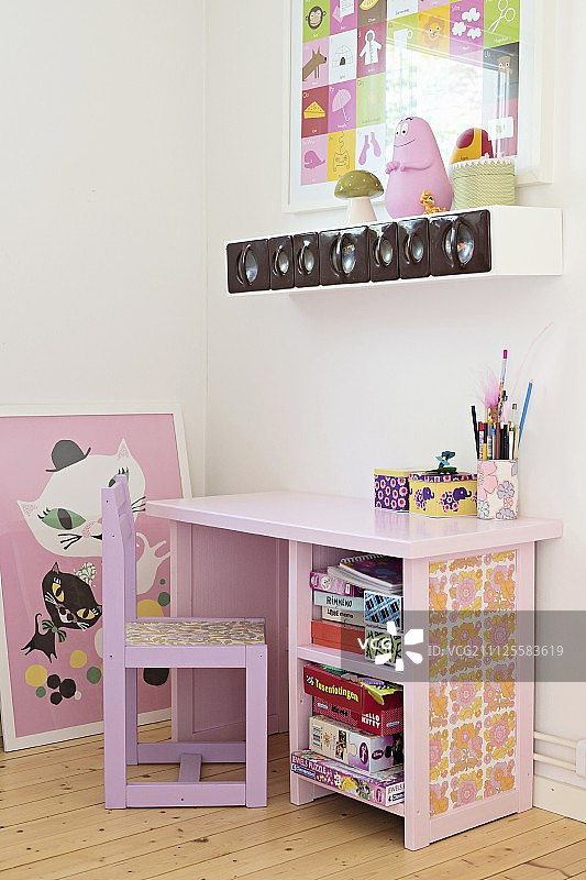 墙上挂着香料架下面粉红色的儿童桌椅图片素材