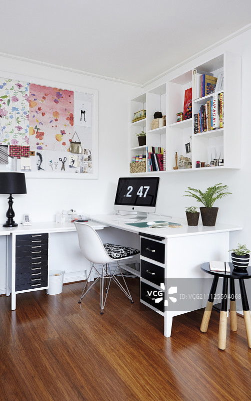 白色的l型办公桌，黑色的抽屉，经典的椅子和浸染的凳子图片素材