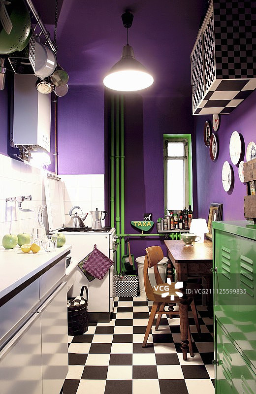 紫色的墙壁，绿色的金属储物柜，小厨房里的加热管道和格子地板图片素材