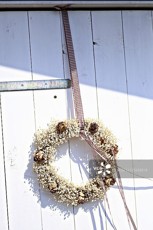 农场门上的gypsophila花环和干玫瑰图片素材