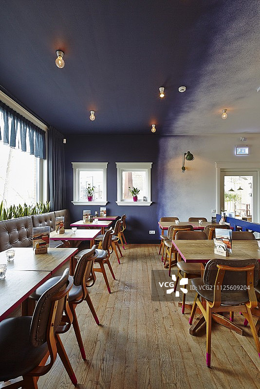 蓝墙餐厅的木桌和皮椅图片素材
