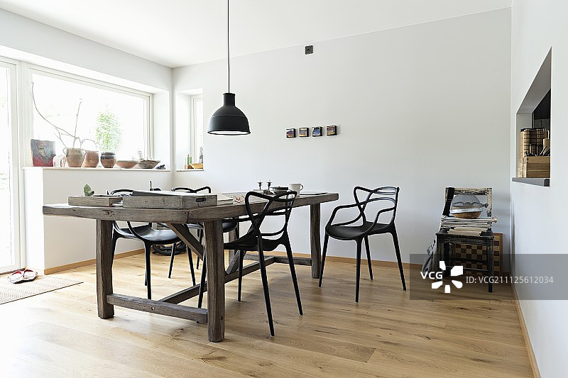 质朴的木桌和设计师的椅子在极简主义餐厅图片素材