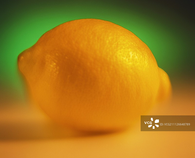 一个柠檬在绿色和黄色的背景图片素材