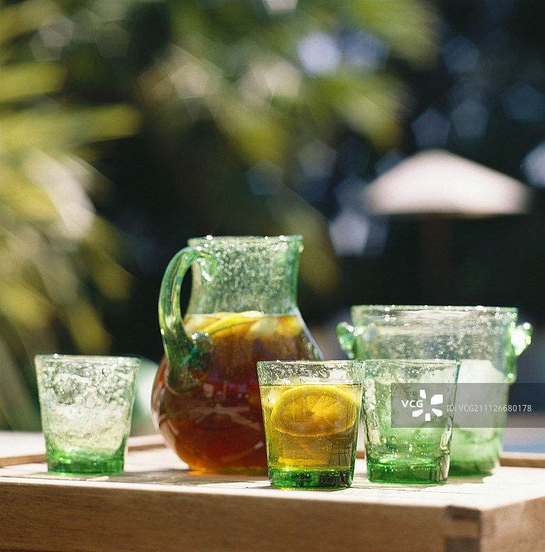 冰茶与柠檬玻璃壶在桌子上;眼镜;冰桶图片素材