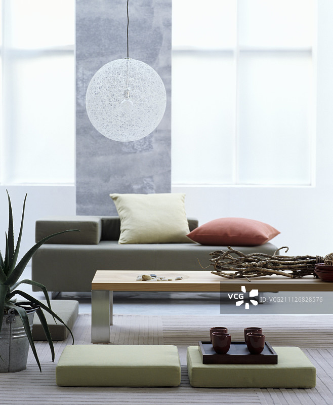 一个东方风格的客厅，有沙发、咖啡桌和地垫图片素材