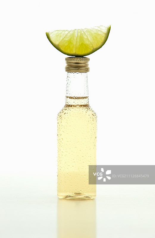 一小瓶龙舌兰酒，上面放一个青柠角图片素材