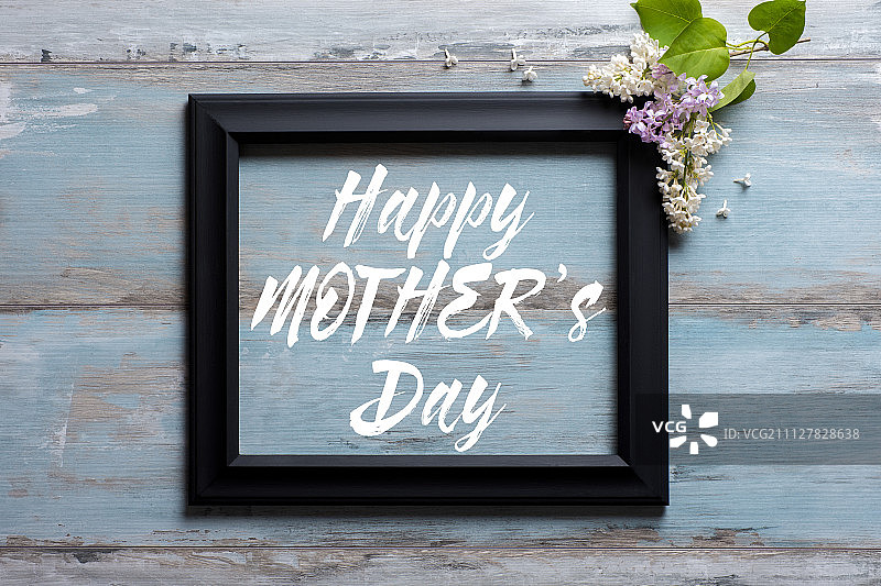 画框与丁香花和母亲节快乐的消息在蓝色木制背景图片素材