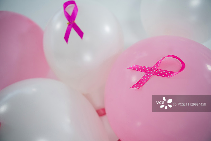 在白色背景下气球上的粉色乳腺癌意识丝带特写图片素材