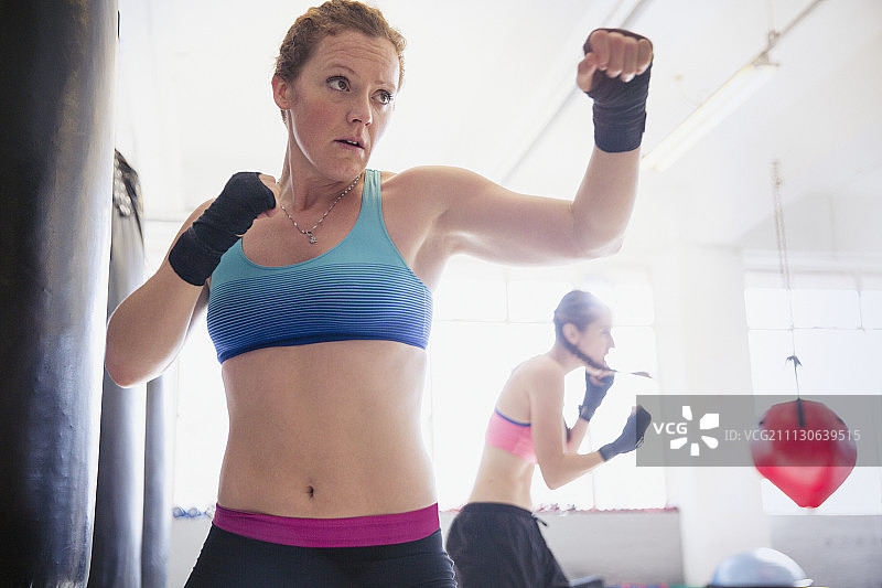 意志坚定，坚强的女拳击手在健身房打太极拳图片素材