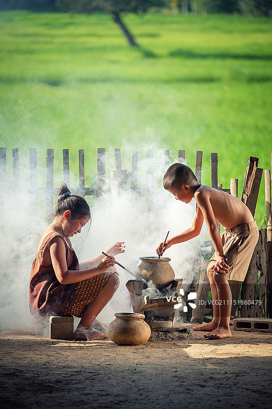 亚洲儿童男孩和女孩正在烹饪在公司的图片素材