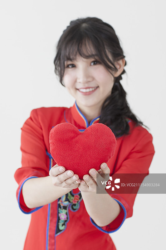 年轻女人穿着旗袍拿着一个爱心图片素材
