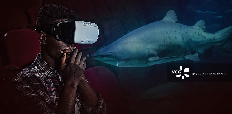 人戴着虚拟现实头盔在剧院的合成图像图片素材