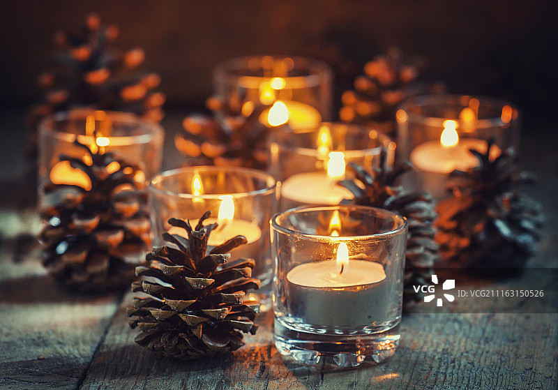 用木头桌子上的蜡烛和圆锥做成的圣诞节装饰品图片素材