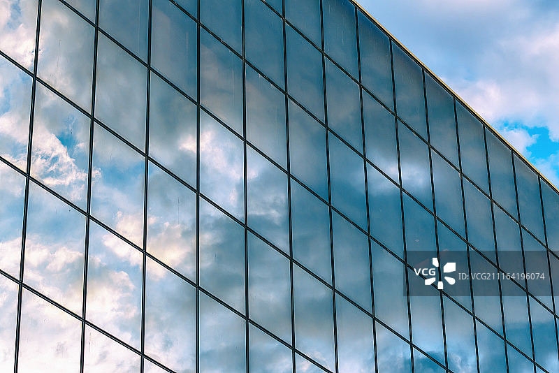 蓝天下反光洁净的现代建筑玻璃幕墙图片素材